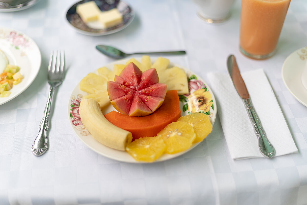 Mesa de desayuno preparada con mantel y servicio completo